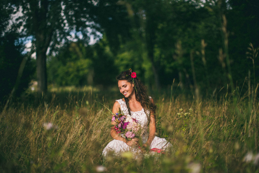 071 Mukwonago Milwaukee WI Barn DIY Laid-back Sweet Bride Sitting On Ground on Wedding Dress Tall Grass Adventurous Danny Andrea