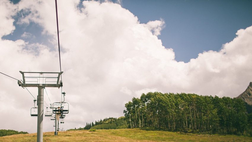 Bride and groom on red lady express ski lift crested butte to uleys