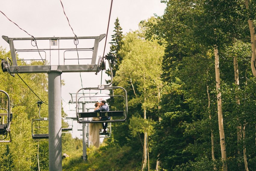 Bride and groom on red lady express ski lift crested butte to uleys