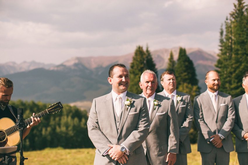 Happy groom's face seeing bride for the first time down aisle