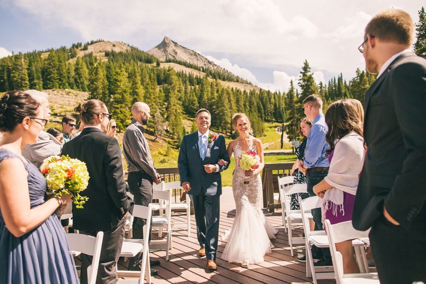 beautiful bride jessica walks down the aisle with father in crested butte uleys cabin