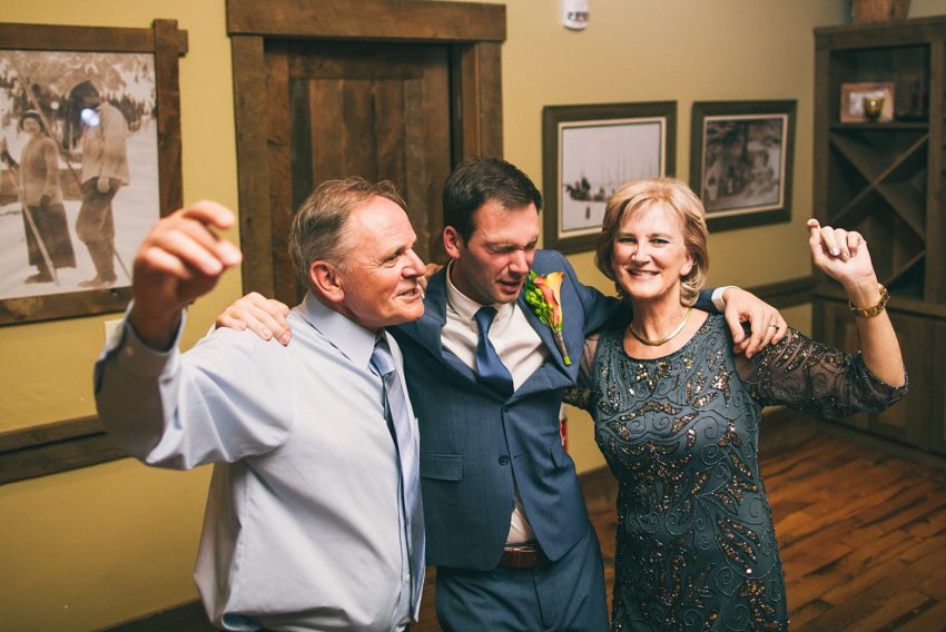 groom enjoying wedding reception at uleys cabin with parents