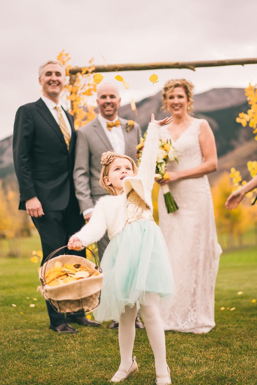 Flower girl tossing flower in the air crested butte fall colors aspen