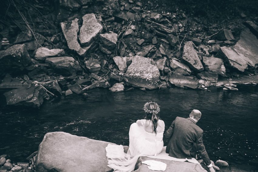 christian Bride and groom foot washing ceremony down at the River At lyons colorado River bend