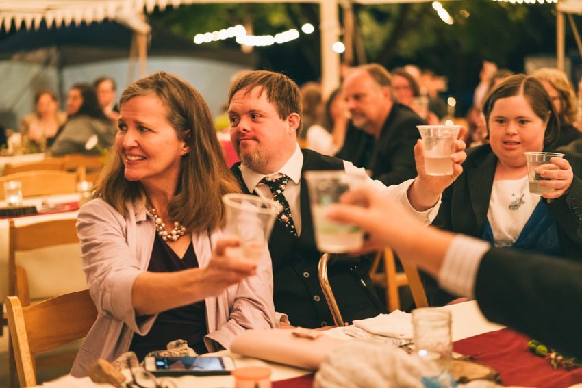 Wedding guest cheering for bride and groom during toast