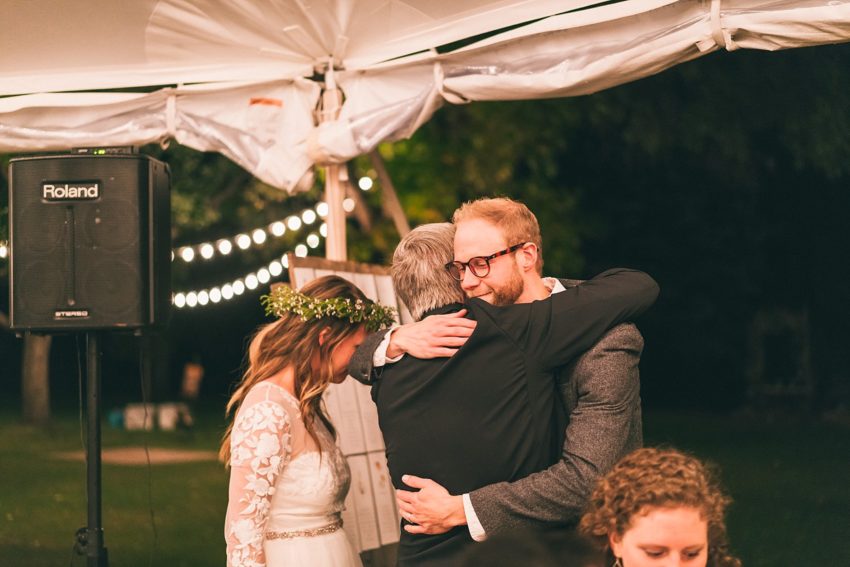 Father of the bride hugging groom welcoming him into the family