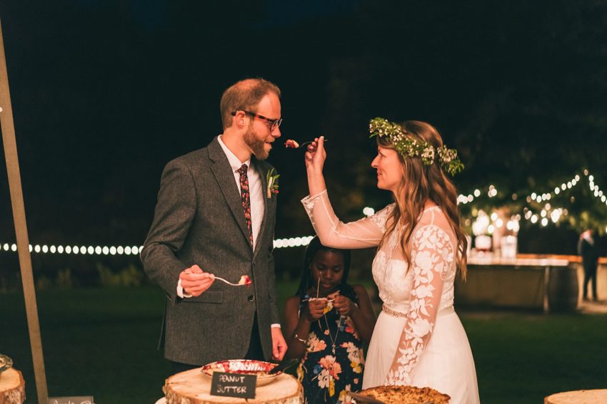 Brad and groom feed each other pie